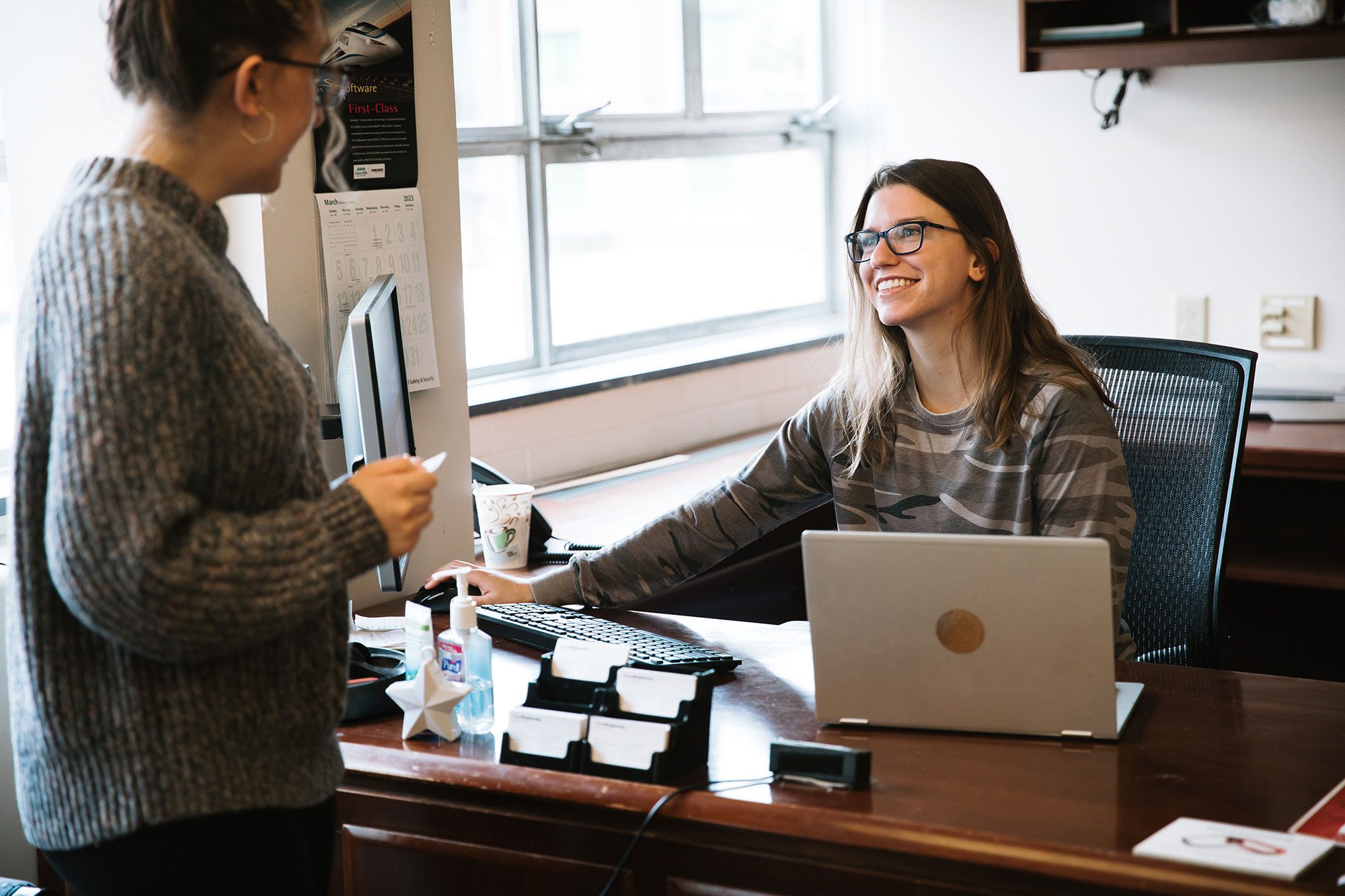 Career Center peer advisor talks with student at office desk