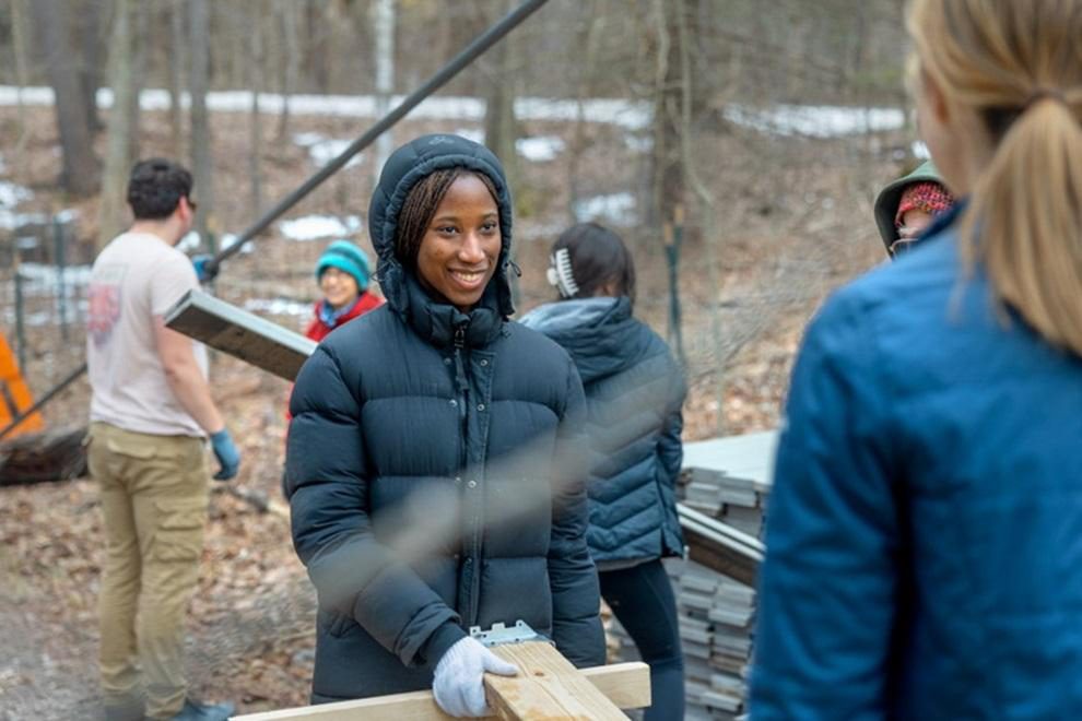 Azeezah Ladoja works with other students on repairs to the flat rock bridge