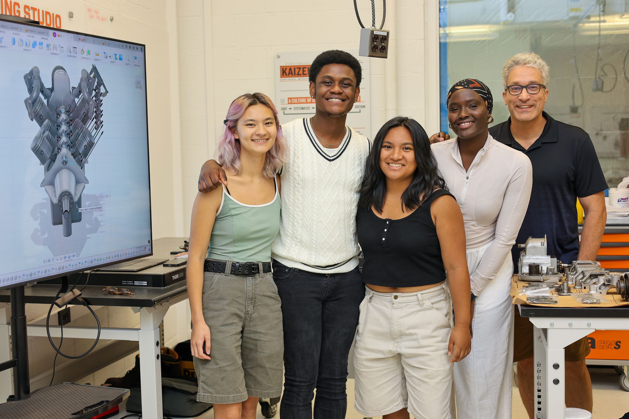 Brian Kirby stands with four smiling students at Toyota Learning Studio