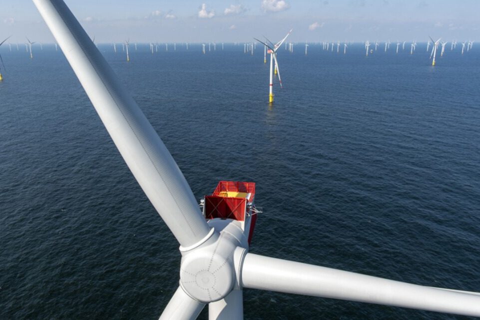 Aerial view of a wind turbine array in the ocean.