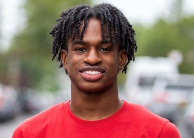 Black student in a red t shirt outside
