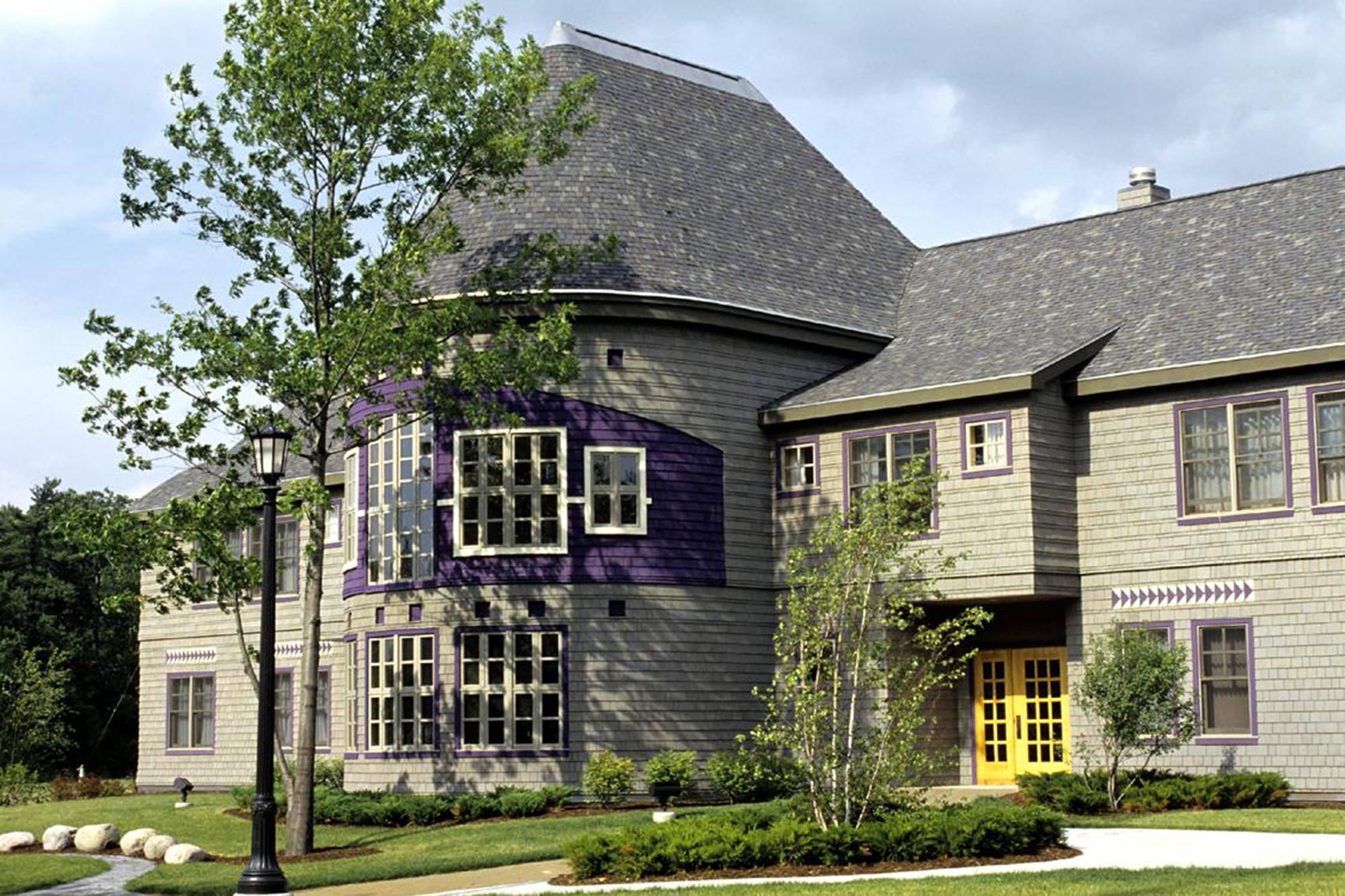 Large house on a sunny day, with greenery outside