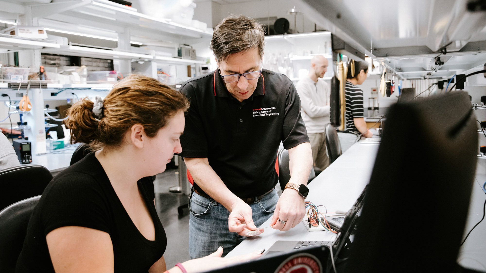 Professor teaching a student in a lab