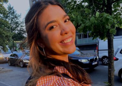 Female student smiling outside on a sunny day