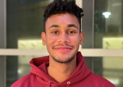 Male student wearing a red hoodie smiling