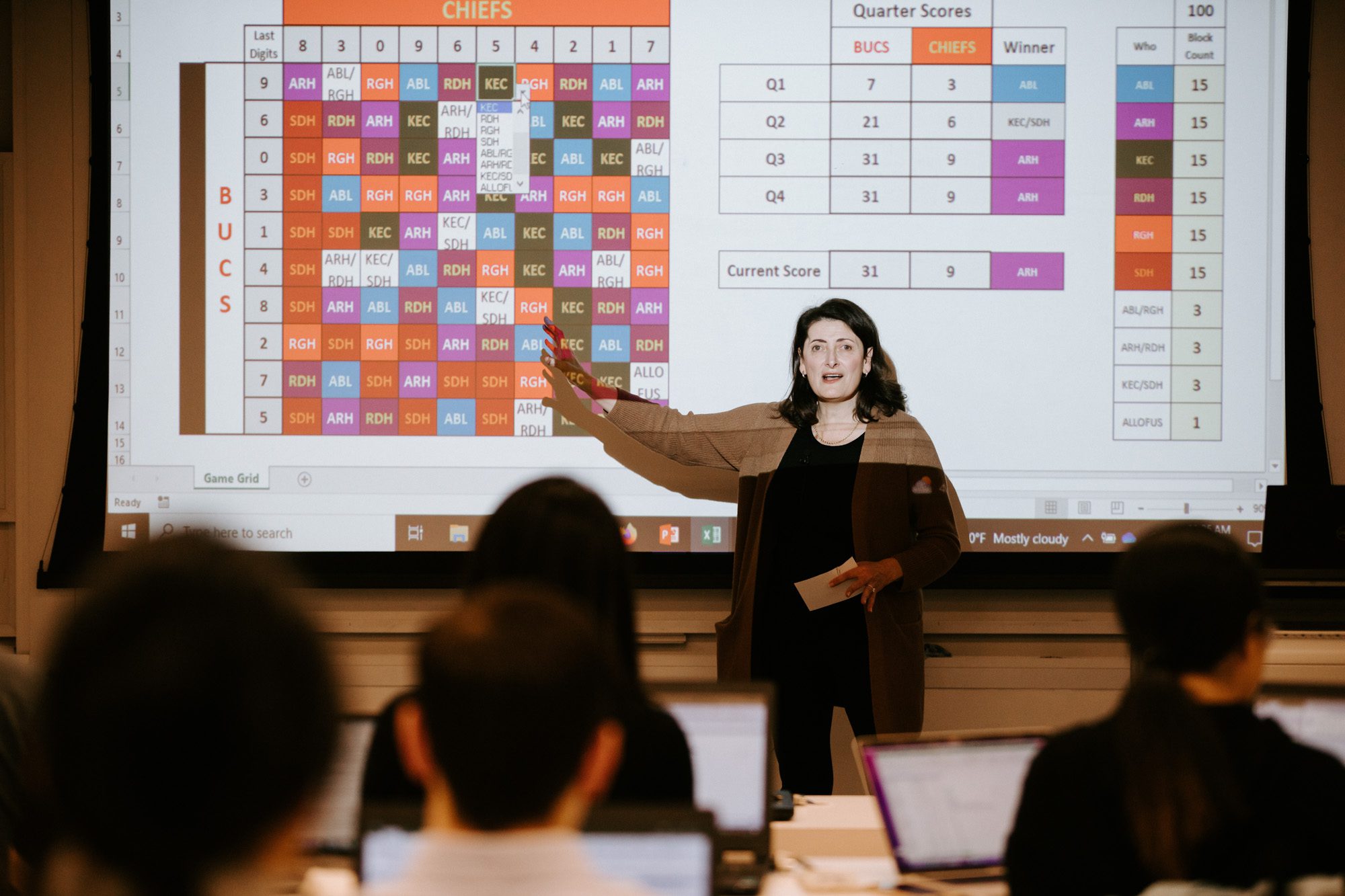 Kathryn Caggiano gives lecture and points to screen