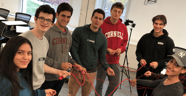 seven students hold a rope as part of a group activity