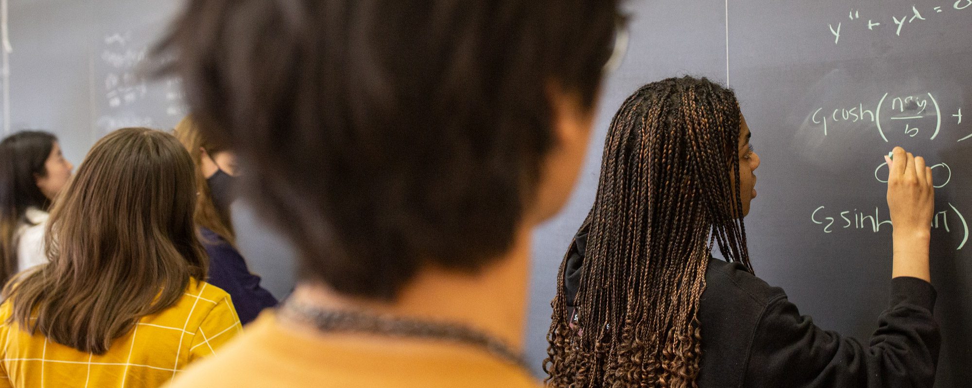 Students work together on a whiteboard