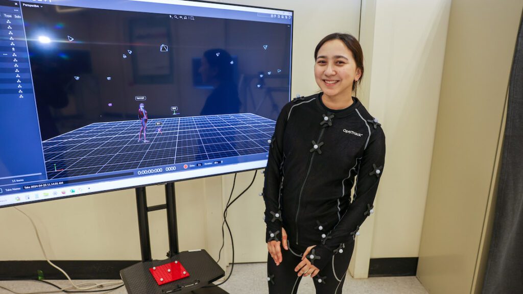 student in motion suit in front of monitor